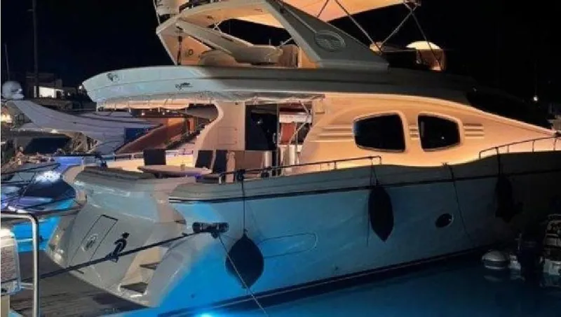  Yacht Photos Pics Luxury Posillipo 65 yacht, 2005 model, illuminated at night in a marina.