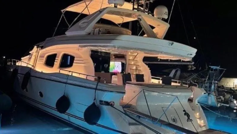  Yacht Photos Pics Luxurious 2005 Posillipo 65 yacht illuminated at night in a marina setting.