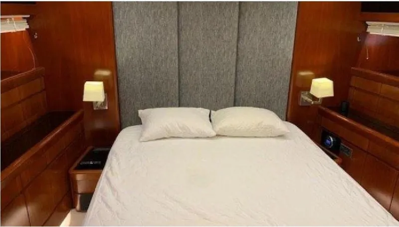  Yacht Photos Pics Luxurious bedroom interior of 2005 Posillipo 65 yacht with elegant wood paneling.