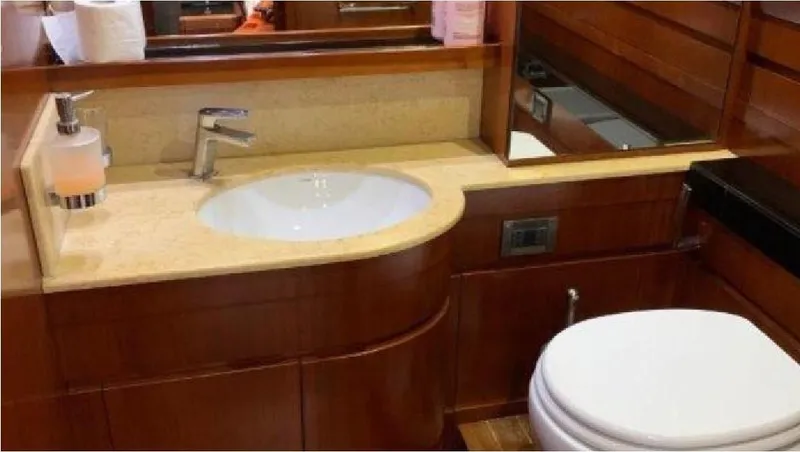  Yacht Photos Pics Luxurious bathroom interior on a 2005 Posillipo 65 yacht, featuring wooden cabinetry and modern fixtures.