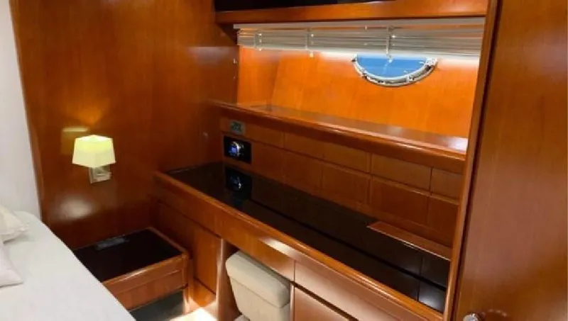  Yacht Photos Pics Luxurious wooden interior of a 2005 Posillipo 65 yacht cabin with elegant furnishings.