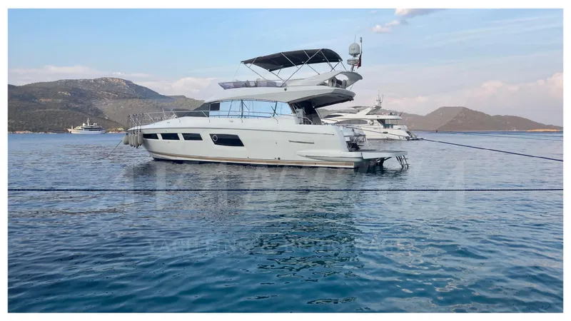  Yacht Photos Pics 2012 Prestige 500 yacht anchored in serene blue waters with mountainous backdrop.