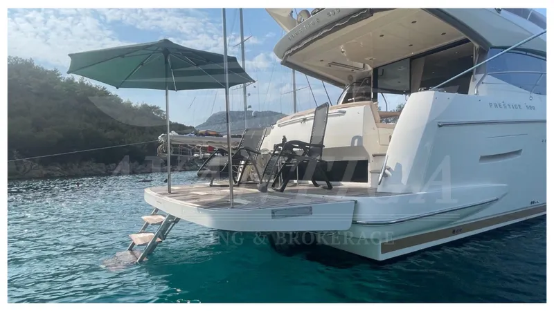 Yacht Photos Pics Luxury 2012 Prestige 500 yacht with deck chairs and umbrella on calm water.
