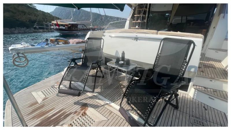  Yacht Photos Pics Deck of 2012 Prestige 500 yacht with chairs and table, overlooking serene waters.