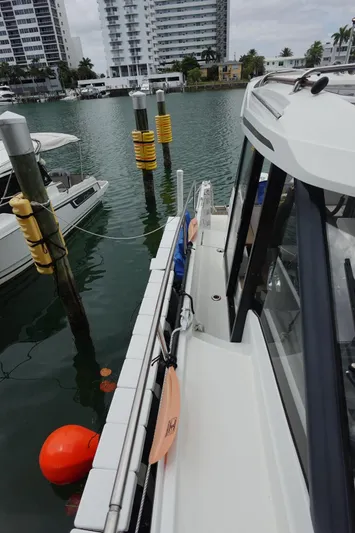  Yacht Photos Pics 2021 Jeanneau NC 895 docked at marina with cityscape background.