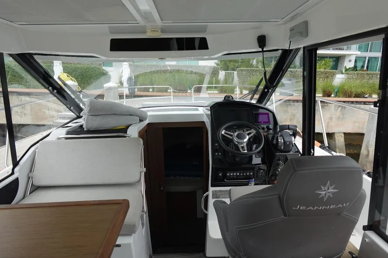  Yacht Photos Pics 2021 Jeanneau NC 895 boat interior with helm, steering wheel, and seating area.
