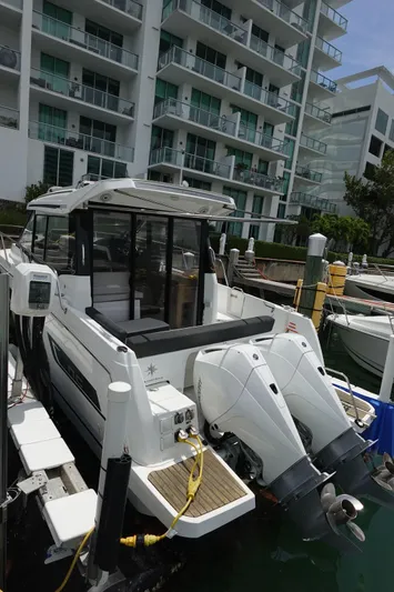  Yacht Photos Pics 2021 Jeanneau NC 895 boat docked near modern waterfront apartments.