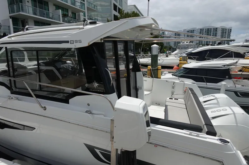  Yacht Photos Pics 2021 Jeanneau NC 895 boat docked at marina, modern design, white exterior.