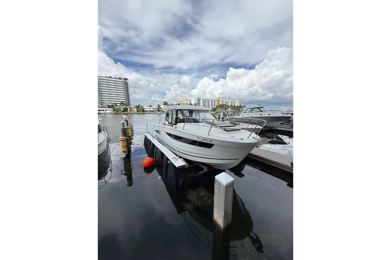  Yacht Photos Pics 2021 Jeanneau NC 895 boat docked at marina under cloudy sky.