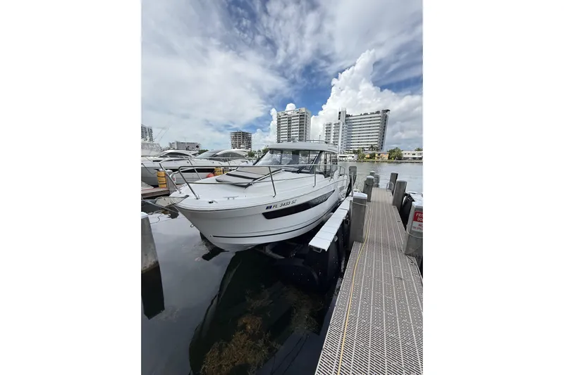  Yacht Photos Pics 2021 Jeanneau NC 895 docked at marina with cityscape background.