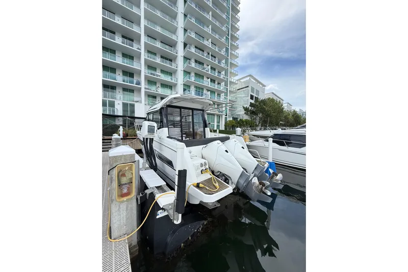  Yacht Photos Pics 2021 Jeanneau NC 895 docked near modern waterfront apartments.