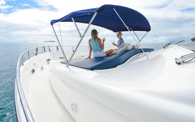  Yacht Photos Pics Two people relaxing on a 2006 Ferretti Yachts 881 under a blue canopy.