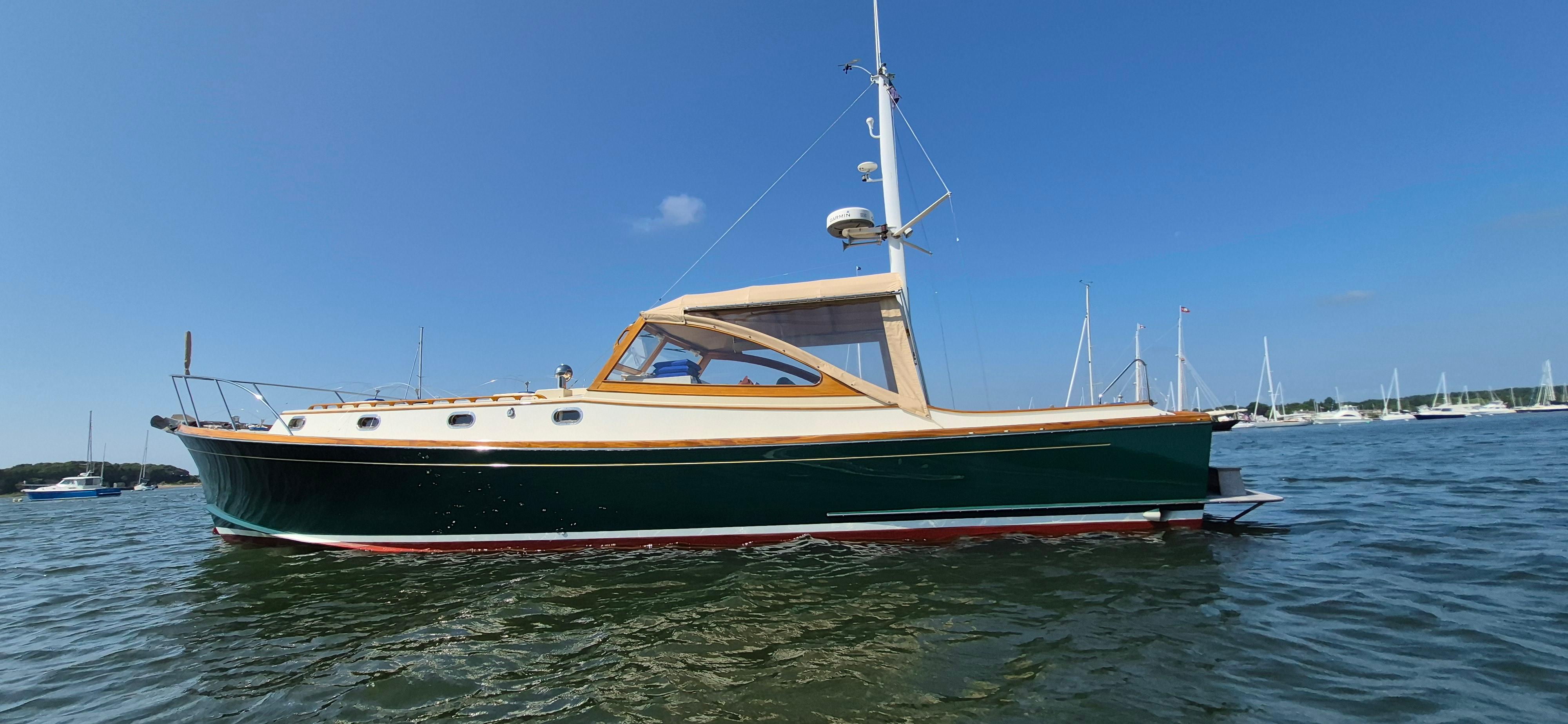 1997 Able 44 Downeast Express Cruiser on calm water, clear sky background.