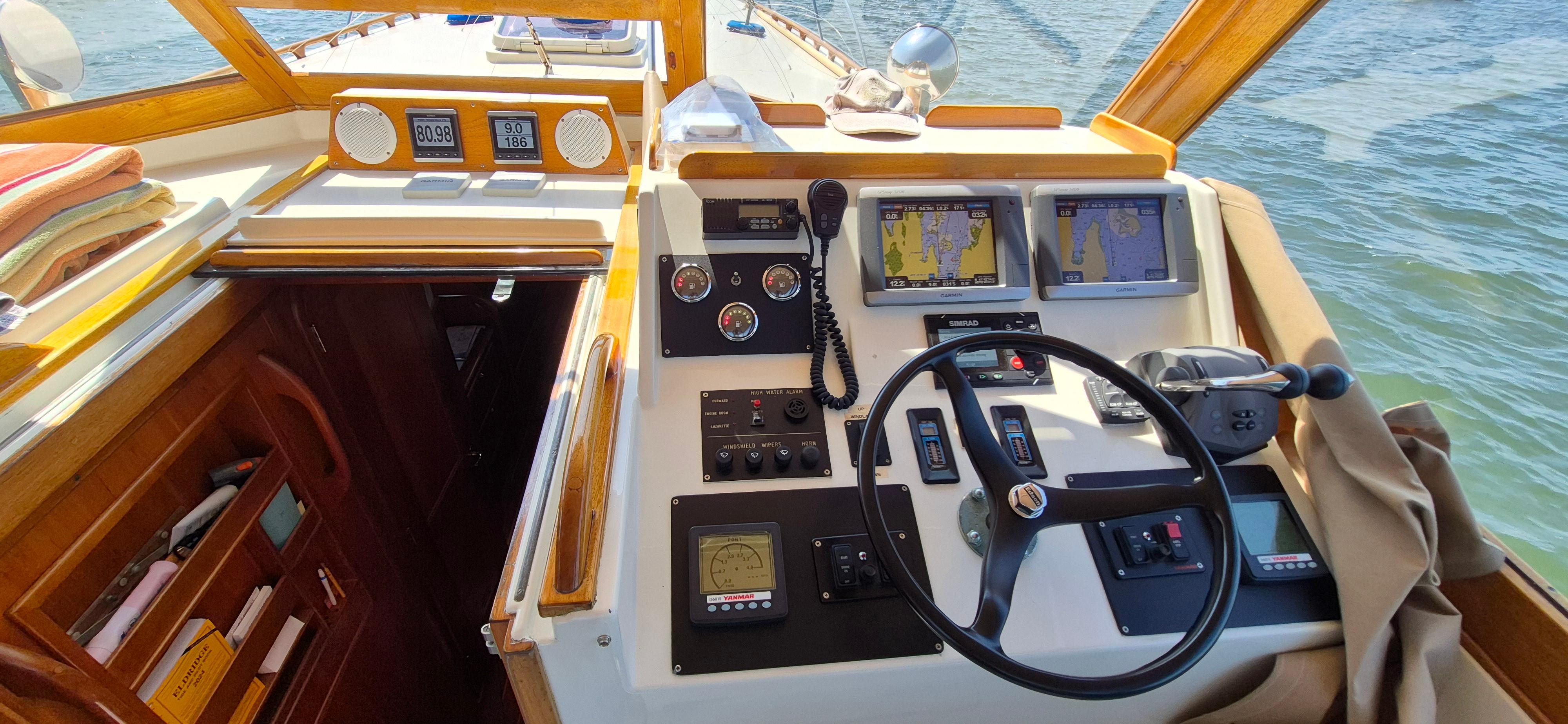 1997 Able 44 Downeast Express Cruiser helm with navigation screens and controls on a sunny day.