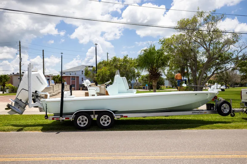  Yacht Photos Pics 2024 Yellowfin 24 CE boat on trailer, parked outdoors under a blue sky.