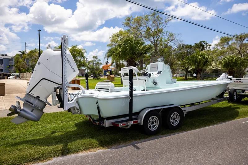  Yacht Photos Pics 2024 Yellowfin 24 CE boat on trailer, parked outdoors under a sunny sky.
