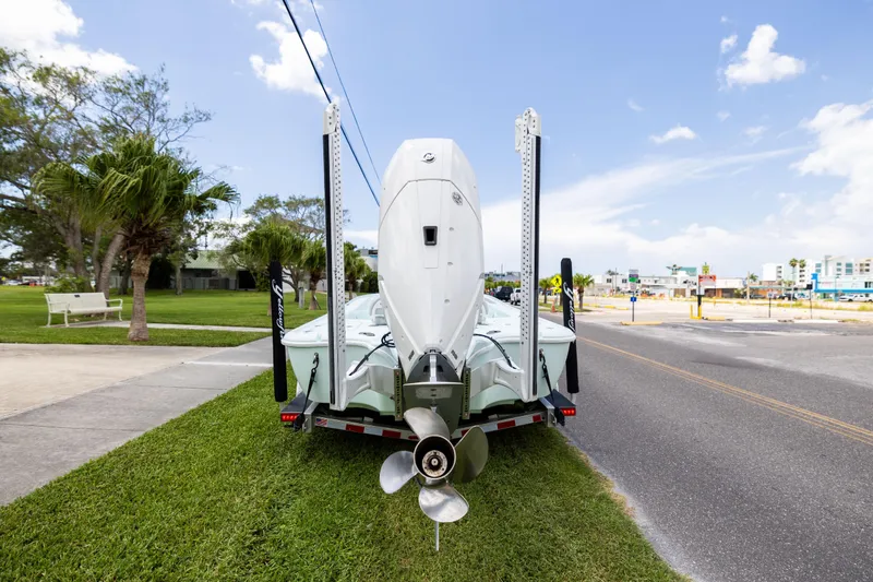  Yacht Photos Pics 2024 Yellowfin 24 CE boat on trailer, parked on grass near road.