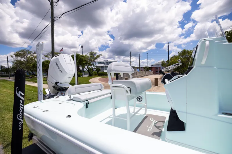  Yacht Photos Pics 2024 Yellowfin 24 CE boat with Mercury engine, docked under a cloudy sky.