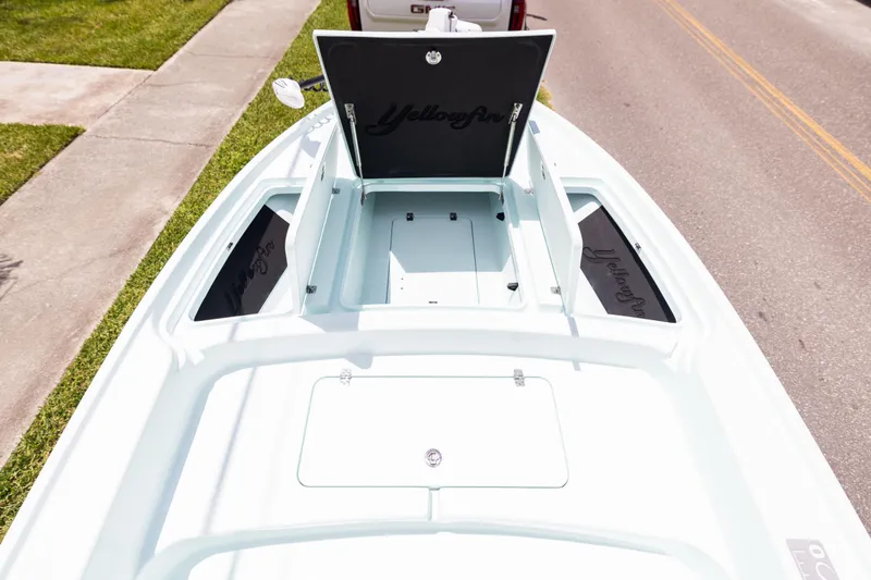 Yacht Photos Pics 2024 Yellowfin 24 CE boat deck with open storage compartments on a sunny day.