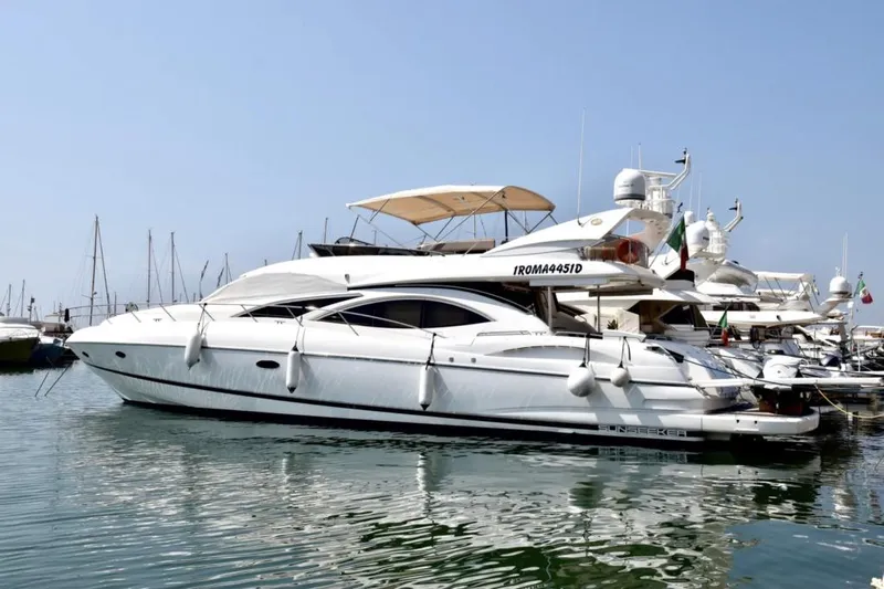  Yacht Photos Pics 2003 Sunseeker Manhattan 74 yacht docked in a marina, surrounded by other boats.