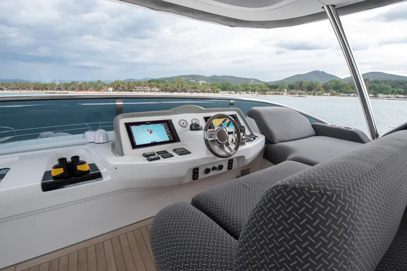 Mahe III Yacht Photos Pics Helm of 2023 Lagoon SIXTY 7 yacht with modern controls and scenic view.