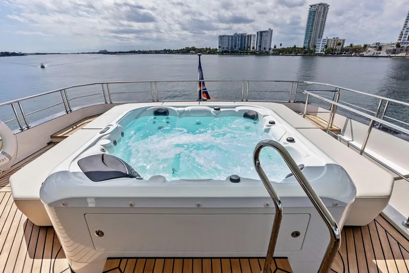 Serenity Now Yacht Photos Pics Luxury yacht Ocean Alexander 35 Revolution 2024 with jacuzzi on deck, overlooking waterfront skyline.