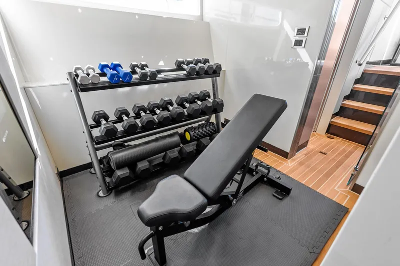 Serenity Now Yacht Photos Pics Home gym with weights and bench on Ocean Alexander 35 Revolution yacht, 2024 model.