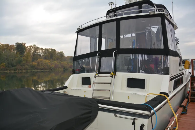 Alaska Sea Duction Yacht Photos Pics 1988 Camargue 48 Cockpit Motor Yacht docked by a serene riverbank.