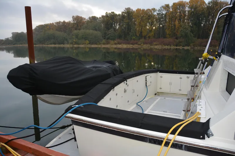 Alaska Sea Duction Yacht Photos Pics 1988 Camargue 48 Cockpit Motor Yacht docked by a serene, wooded shoreline.