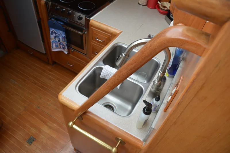 Alaska Sea Duction Yacht Photos Pics 1988 Camargue 48 Cockpit Motor Yacht kitchen with dual sink and wooden cabinetry.