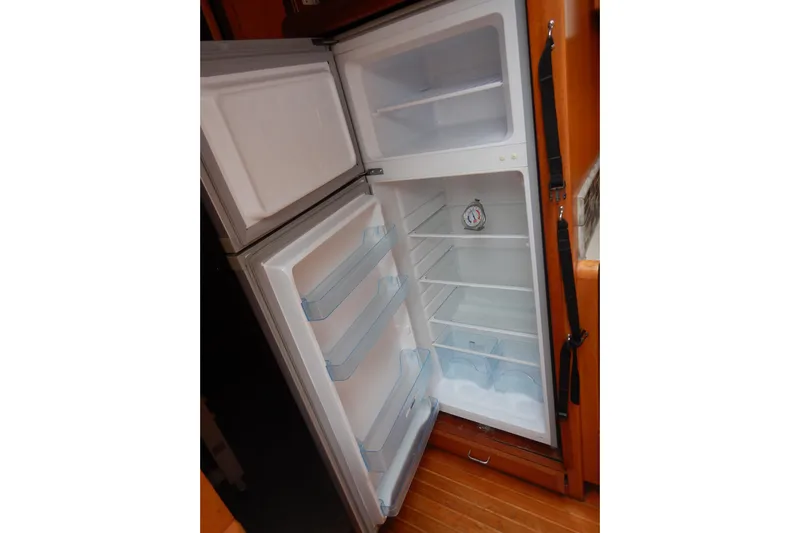 Alaska Sea Duction Yacht Photos Pics Open refrigerator inside 1988 Camargue 48 Cockpit Motor Yacht, showcasing spacious interior shelves.