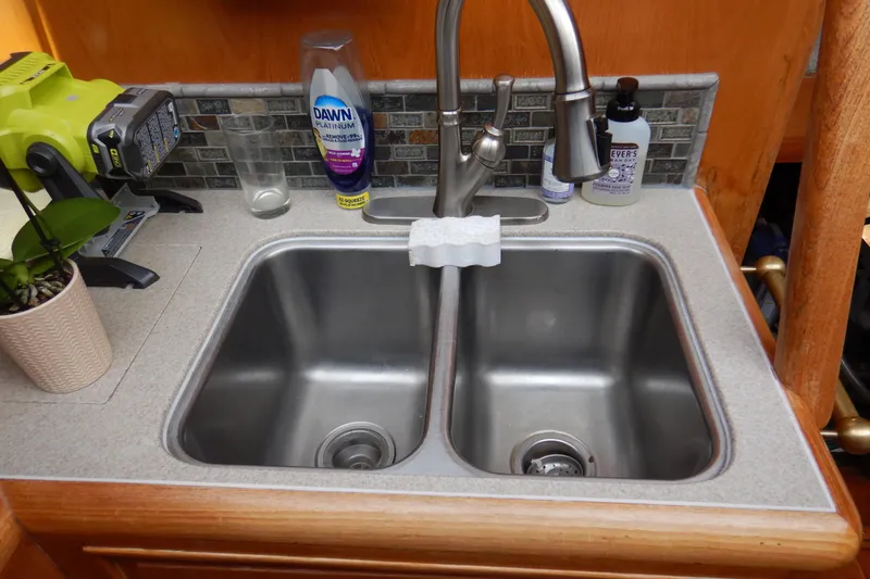 Alaska Sea Duction Yacht Photos Pics Double sink in 1988 Camargue 48 Cockpit Motor Yacht kitchen with cleaning supplies.