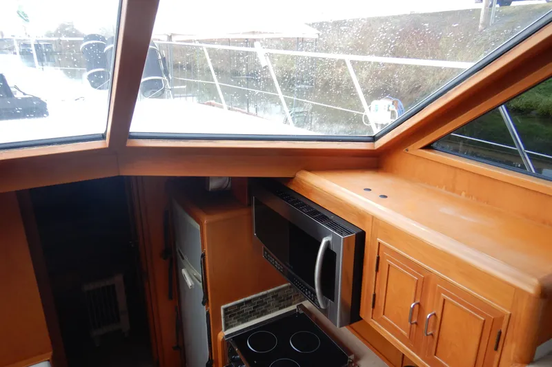 Alaska Sea Duction Yacht Photos Pics Interior view of 1988 Camargue 48 Cockpit Motor Yacht kitchen with microwave and stove.