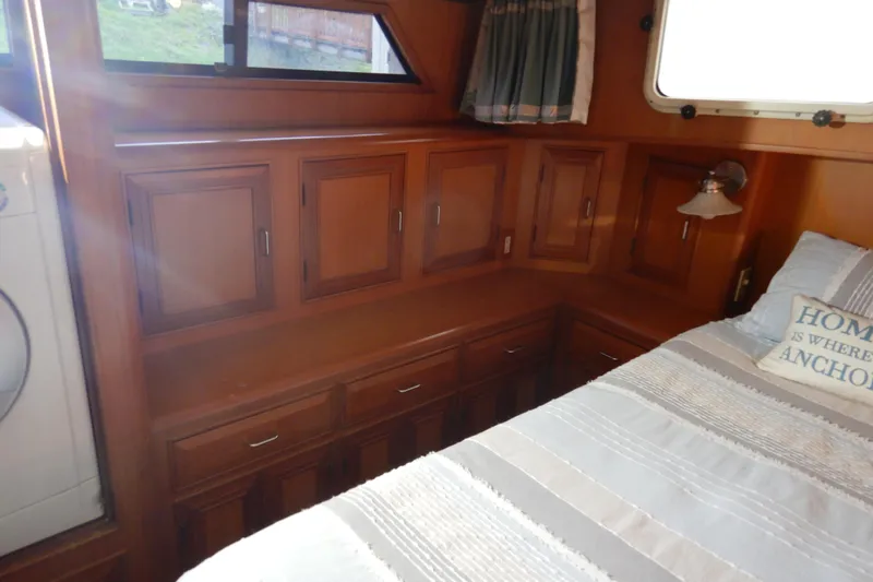 Alaska Sea Duction Yacht Photos Pics 1988 Camargue 48 Cockpit Motor Yacht interior with wood cabinetry and cozy bed.