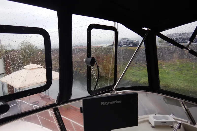 Alaska Sea Duction Yacht Photos Pics Interior view of 1988 Camargue 48 Cockpit Motor Yacht with rain-speckled windows.