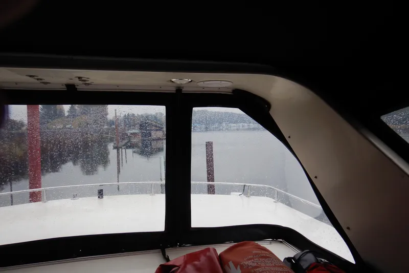 Alaska Sea Duction Yacht Photos Pics Interior view from 1988 Camargue 48 Cockpit Motor Yacht, overlooking rainy marina scene.