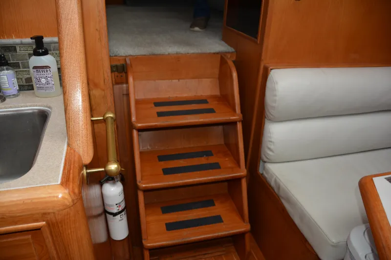 Alaska Sea Duction Yacht Photos Pics Interior of 1988 Camargue 48 Yacht with wooden stairs and seating area.