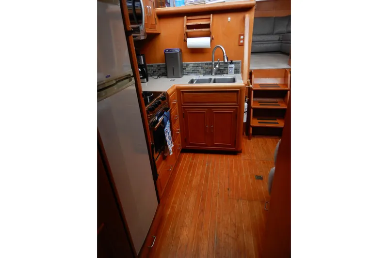 Alaska Sea Duction Yacht Photos Pics 1988 Camargue 48 Cockpit Motor Yacht interior kitchen with wooden cabinetry and modern appliances.