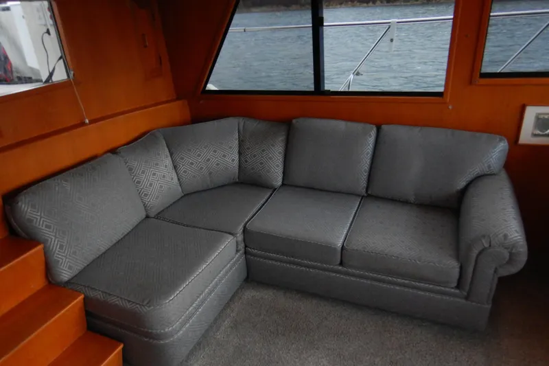 Alaska Sea Duction Yacht Photos Pics Gray sofa in the 1988 Camargue 48 Cockpit Motor Yacht interior, near window.