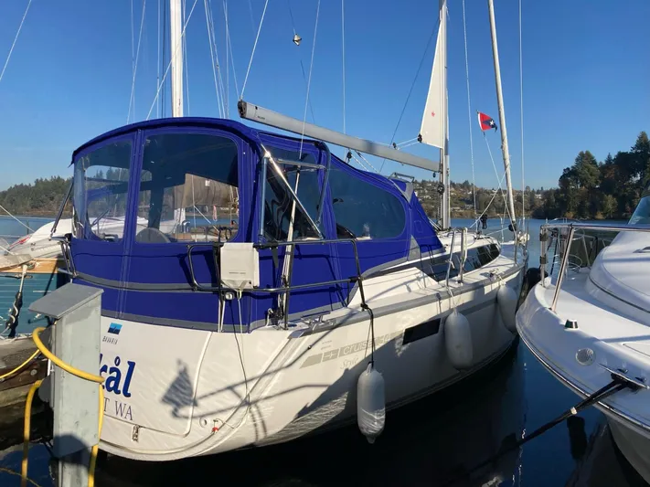 Skal Yacht Photos Pics Sailboat Bavaria Cruiser 34, 2001 model, docked with blue canopy, calm marina setting.