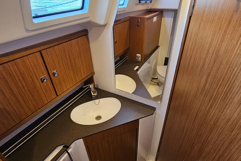 Skal Yacht Photos Pics Bavaria Cruiser 34 (2021) yacht bathroom with wooden cabinets and modern sink design.