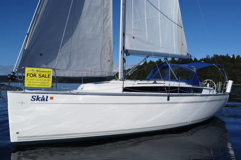 Skal Yacht Photos Pics 2021 Bavaria Cruiser 34 sailboat for sale on calm water, featuring white sails and blue canopy.