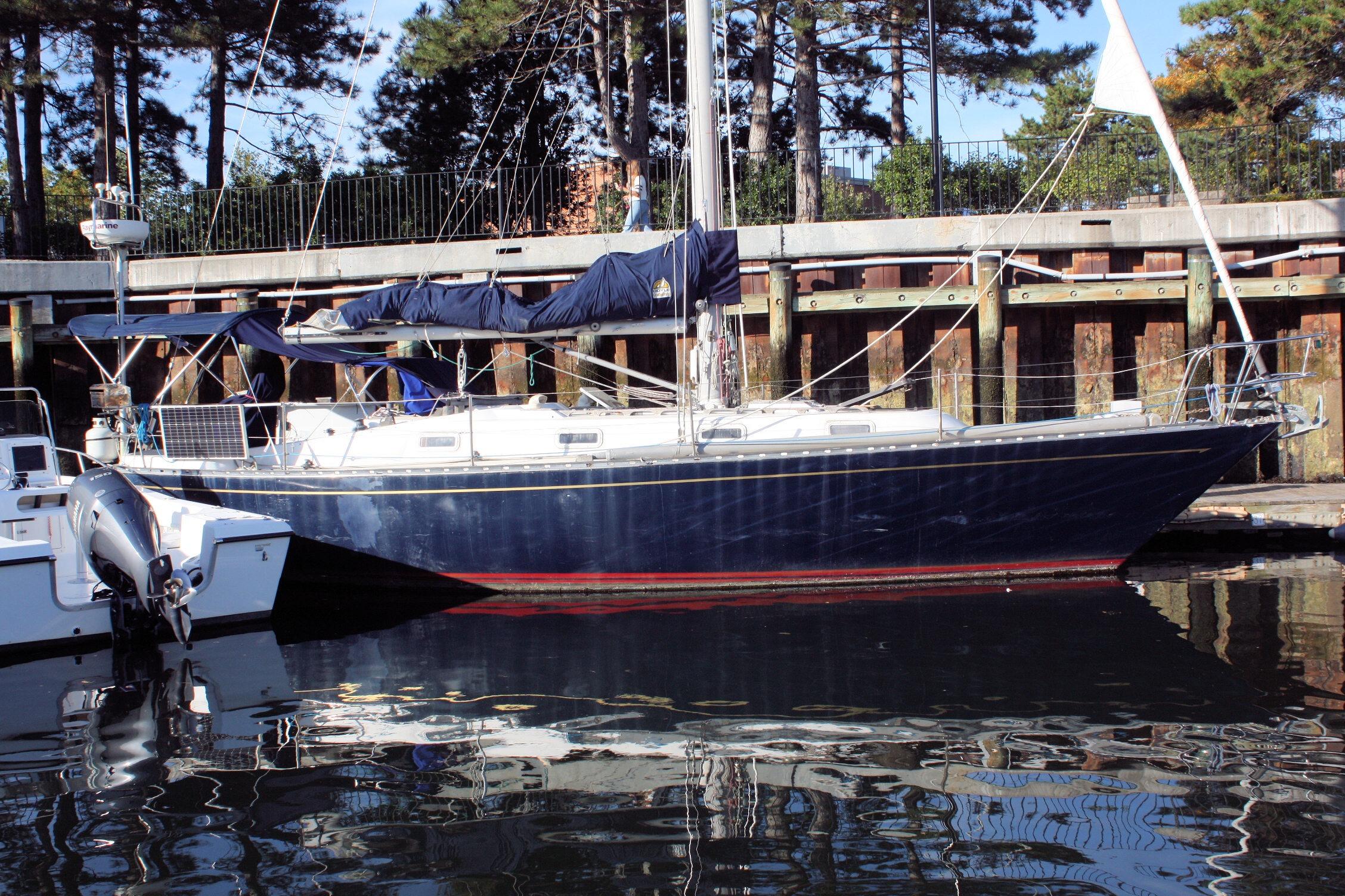 1976 Tartan 38 sailboat docked, featuring a sleek blue hull and covered sails.