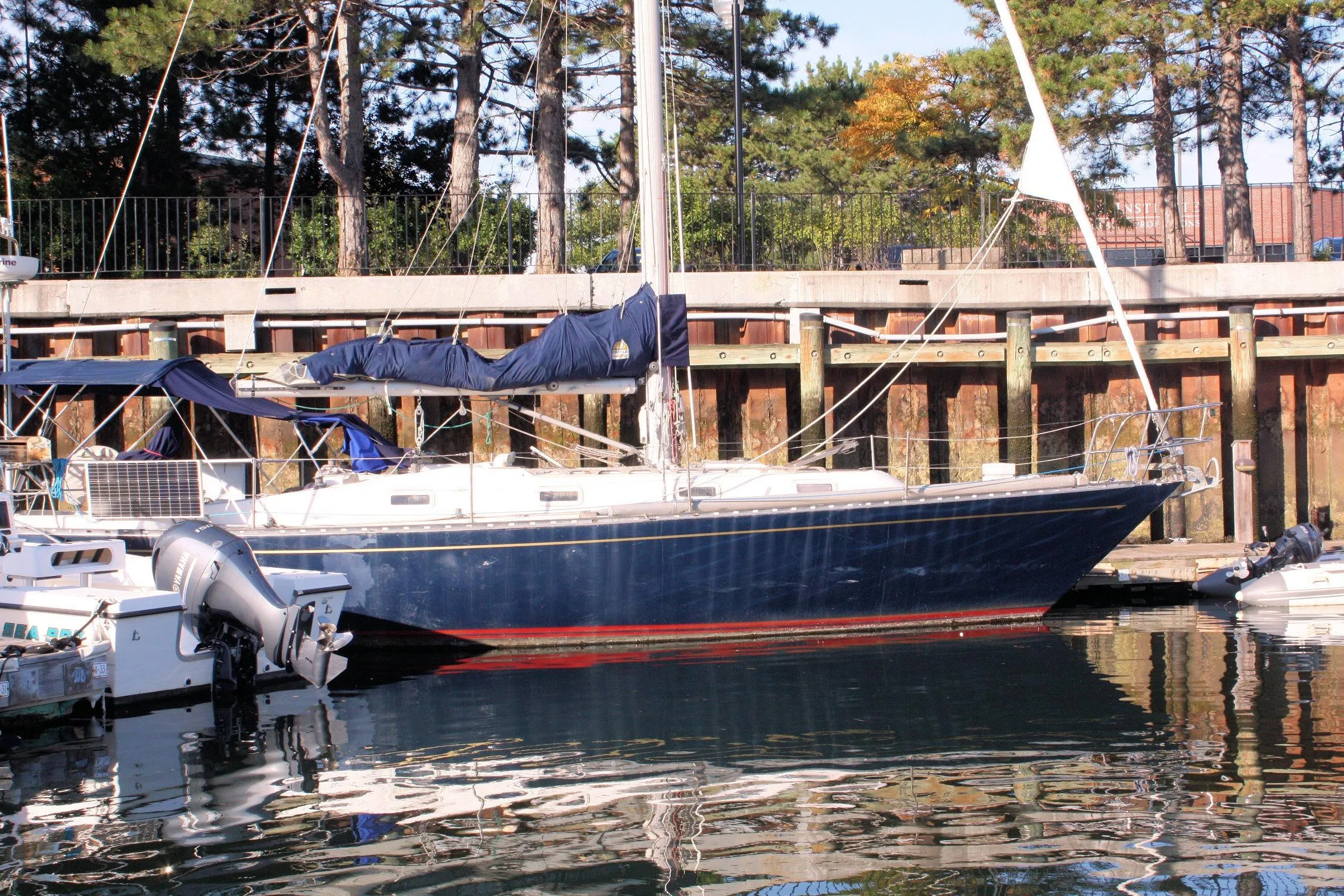 1976 Tartan 38 sailboat docked at a marina, surrounded by trees and calm water.