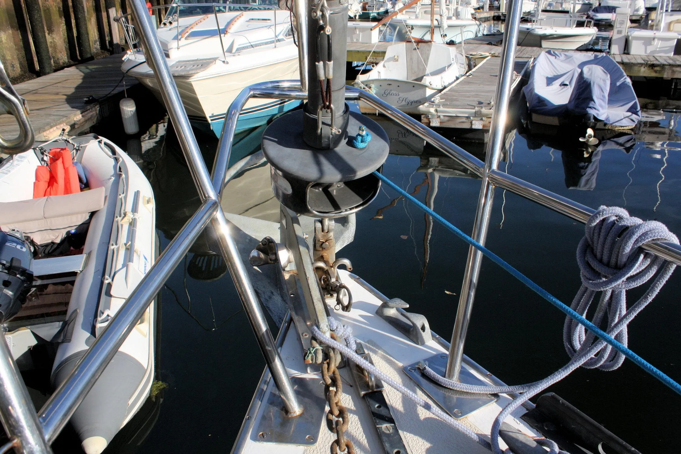 Bow of a 1976 Tartan 38 sailboat docked, with ropes and anchor chain visible.