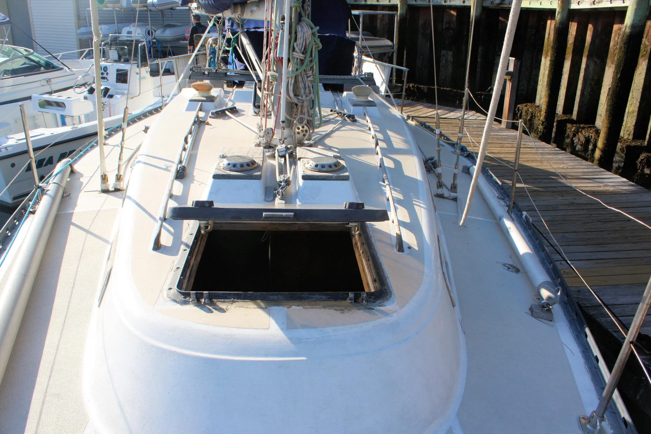 1976 Tartan 38 sailboat deck with open hatch, docked at marina.