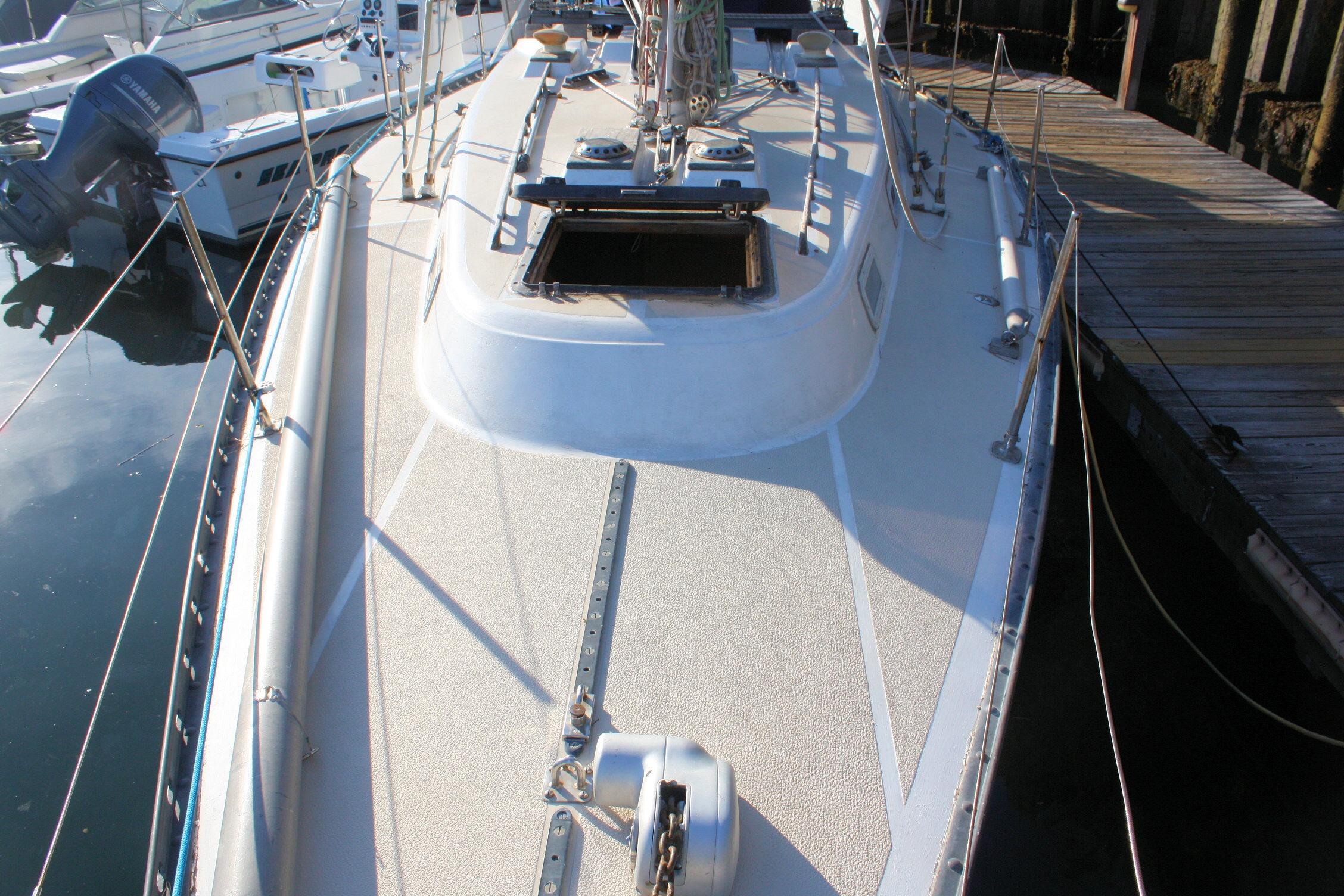 1976 Tartan 38 sailboat docked, showcasing deck and open hatch.