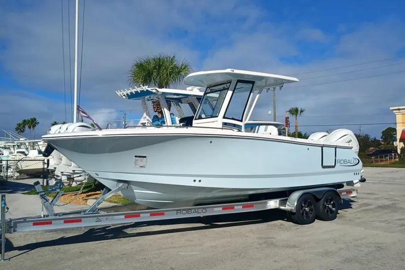 250-118 Yacht Photos Pics 2026 Robalo R250 Center Console boat on trailer, parked outdoors under blue sky.