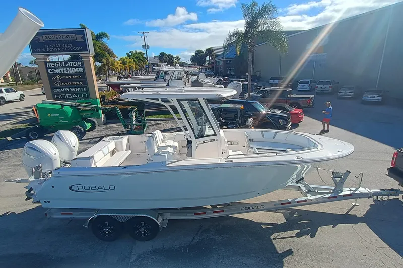 250-118 Yacht Photos Pics 2026 Robalo R250 Center Console boat on trailer in sunny dealership lot.