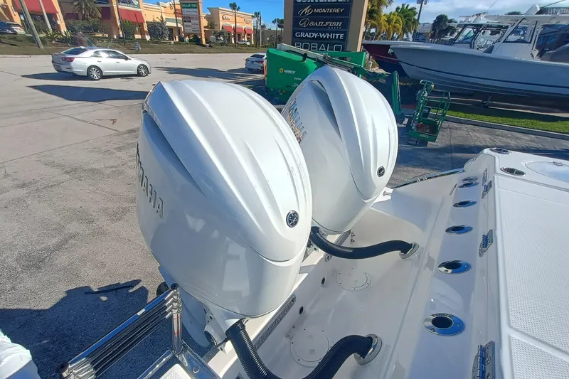 250-118 Yacht Photos Pics 2026 Robalo R250 Center Console with dual outboard engines in a parking lot.